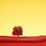 A lone tree stands alone in a red field